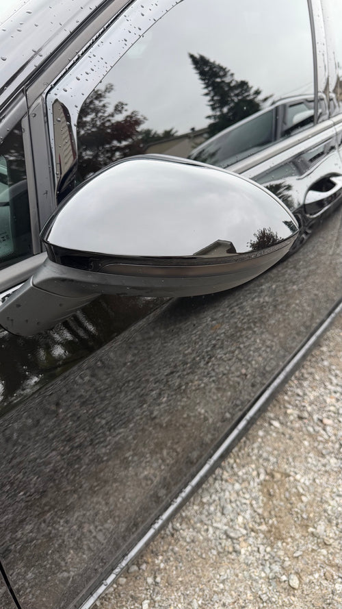 Gloss black mirror cap installed on a Volkswagen Golf MK8, driver-side view
