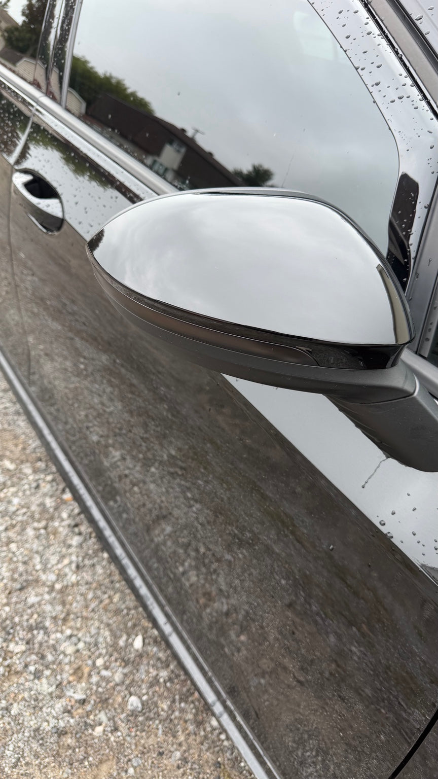 Gloss black mirror cap installed on a Volkswagen Golf MK8, passenger-side view